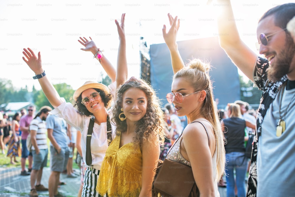 Um retrato de vista frontal de um grupo de jovens amigos dançando no festival de verão.