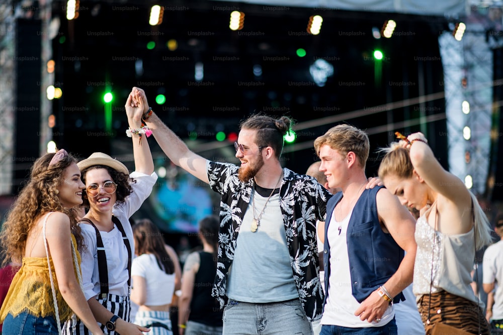 Un grupo de jóvenes amigos alegres bailando en el festival de verano.