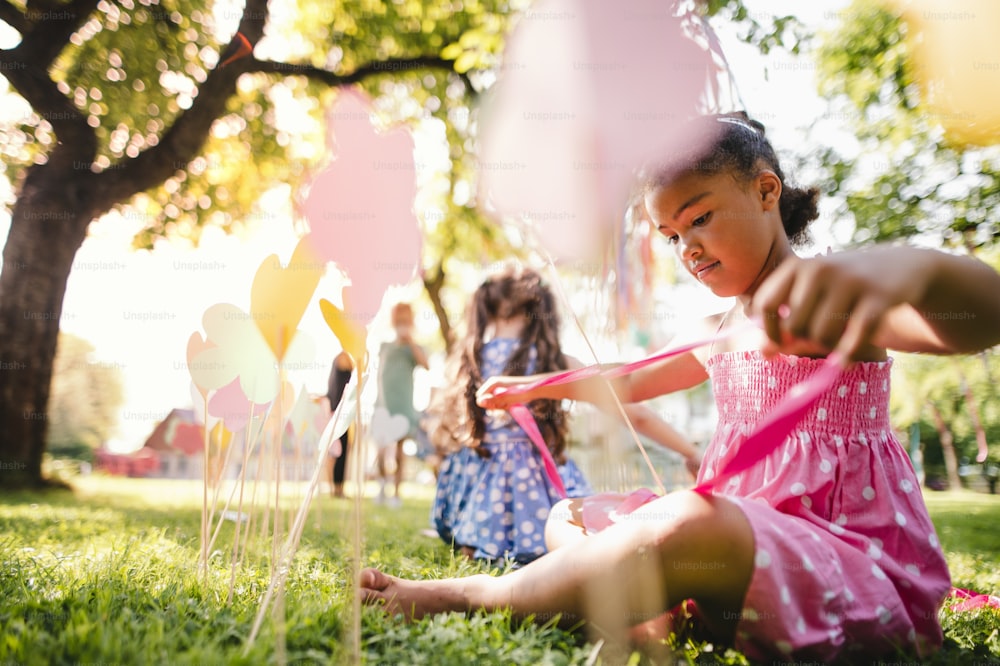 Crianças pequenas ao ar livre no jardim no verão, brincando. Um conceito de celebração.
