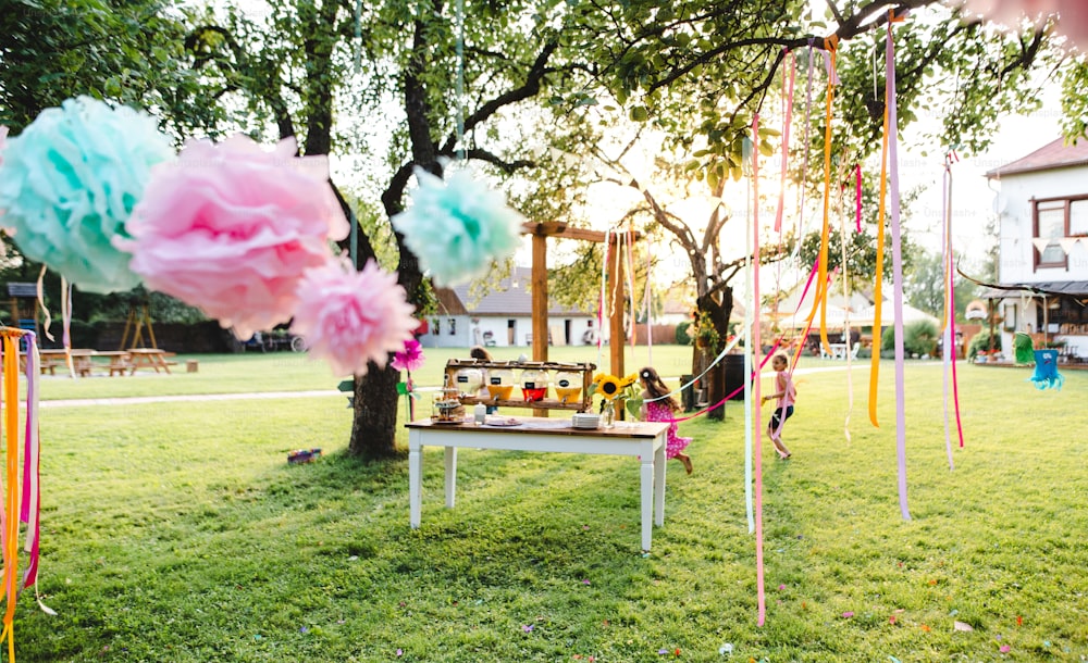 Bambini piccoli all'aperto in giardino in estate, giocando. Un concetto di celebrazione.