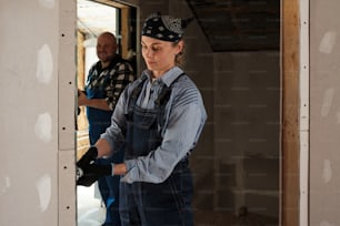 a woman in overalls and a man in a blue shirt
