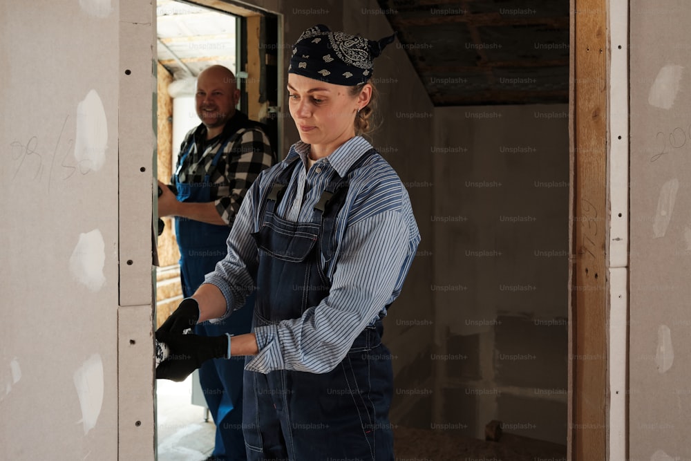 a woman in overalls and a man in a blue shirt