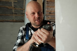 a man holding a drill in his right hand
