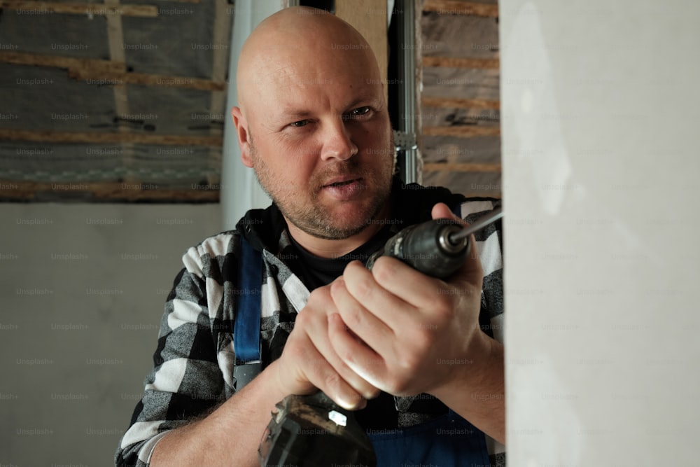 a man holding a drill in his right hand