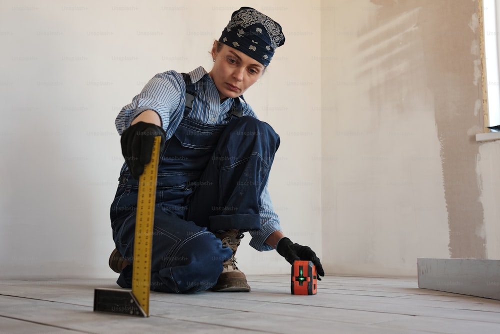 a man sitting on the floor with a tape measure