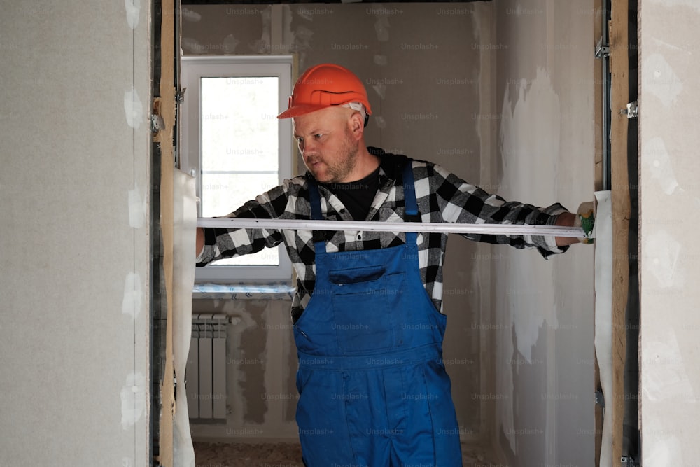 a man in overalls and an orange hat