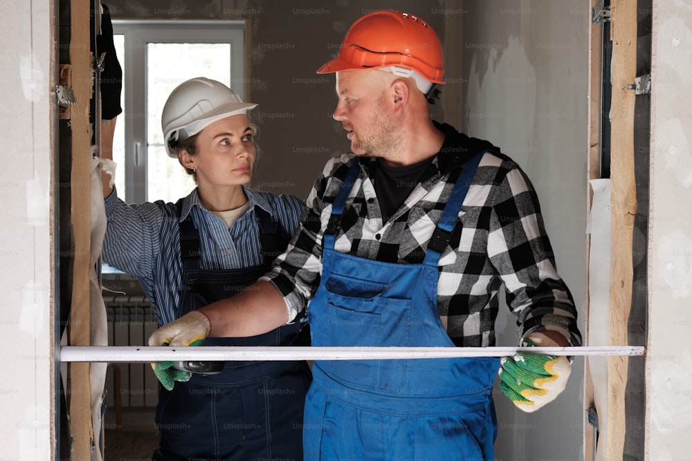 a man and a woman standing in a room under construction