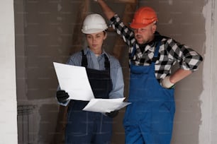 a man and a woman in overalls and hard hats