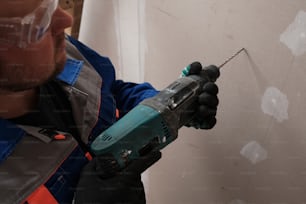 a man in safety gear holding a drill