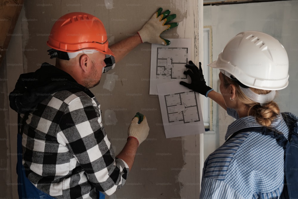 Un homme et une femme travaillant sur un mur