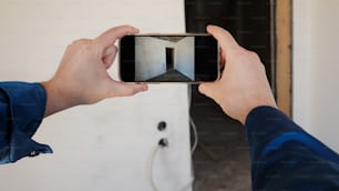 a person holding a cell phone taking a picture of a room