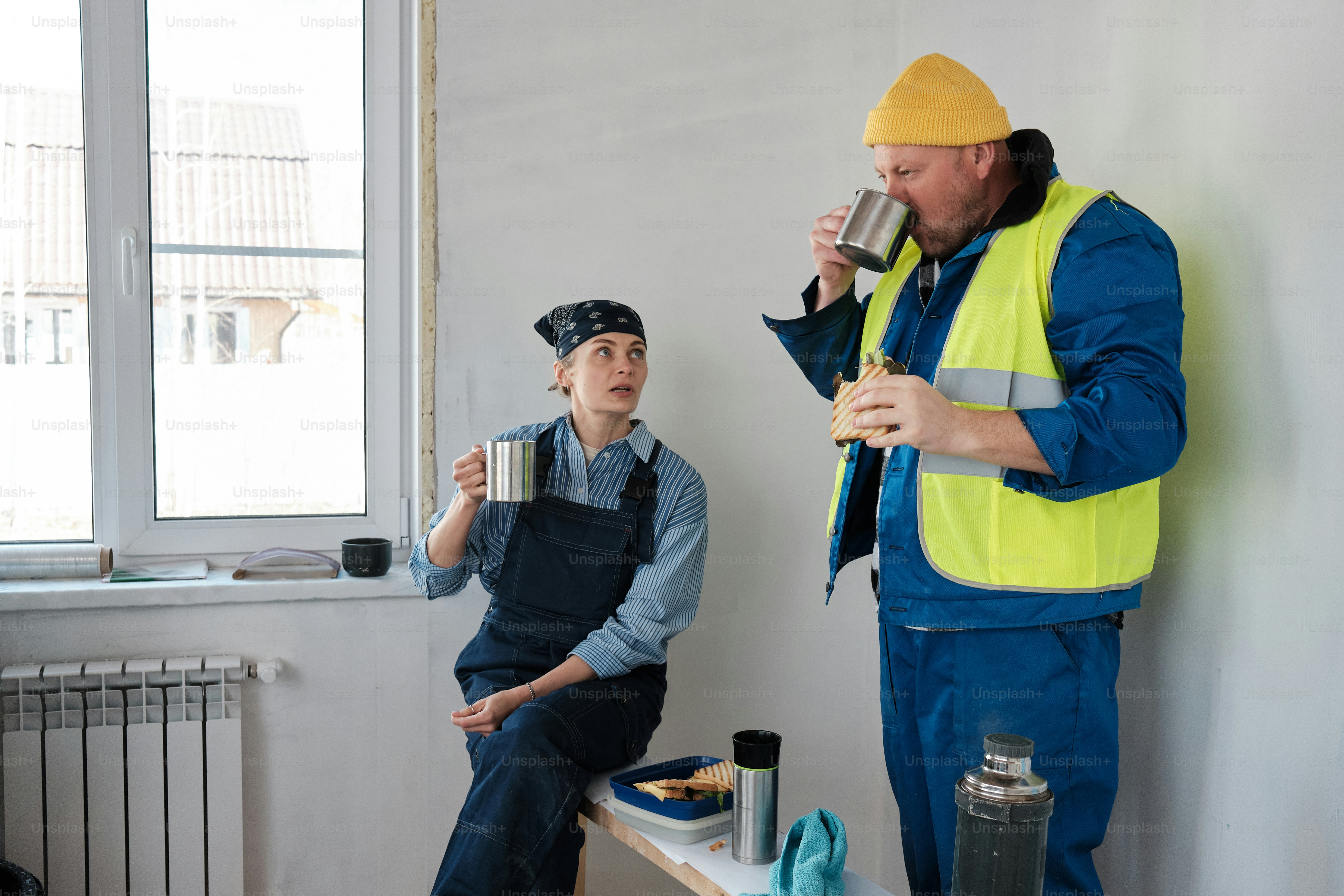 Ein Mann, der neben einem anderen Mann aus einem Becher trinkt