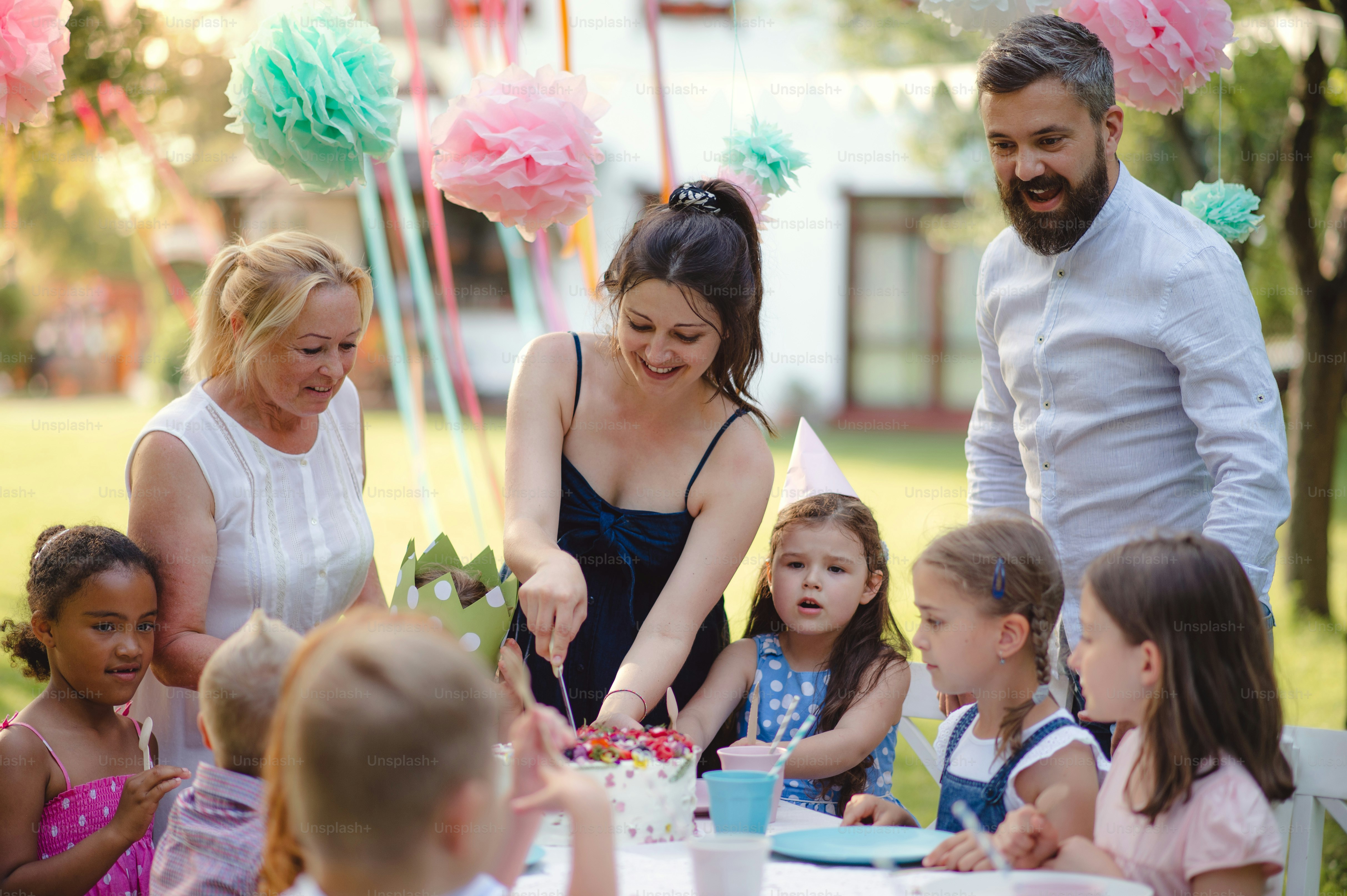 夏の庭で屋外で幸せな子供の誕生日パーティー、お祝いのコンセプト。