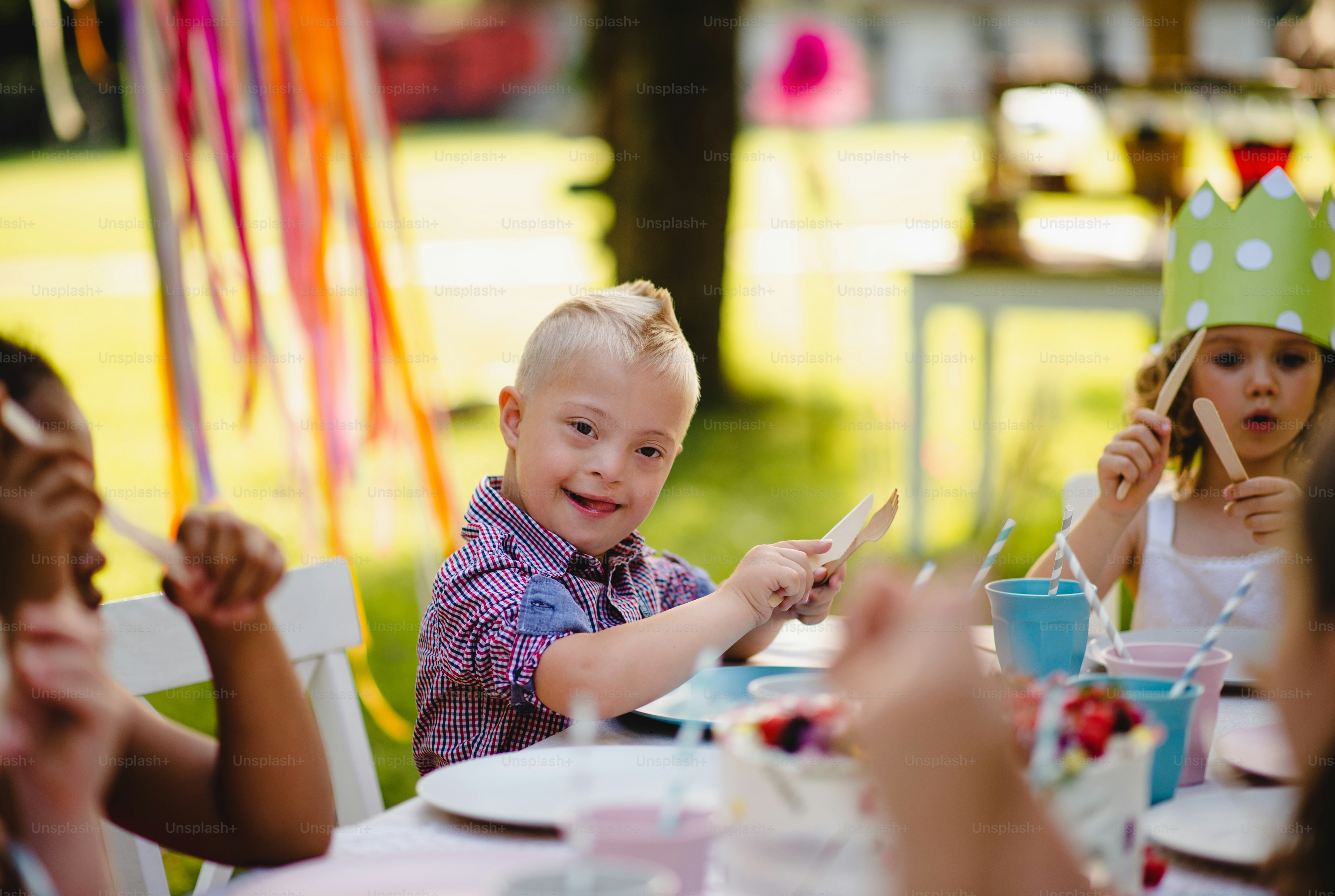 A portrait of children with cake standing around table on birthday ...