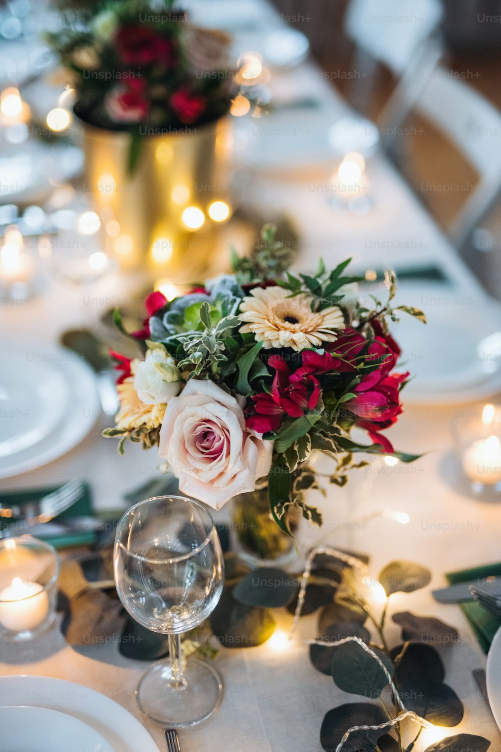Una tavola apparecchiata per un pasto al chiuso in una stanza durante una festa, un matrimonio o una festa di famiglia.
