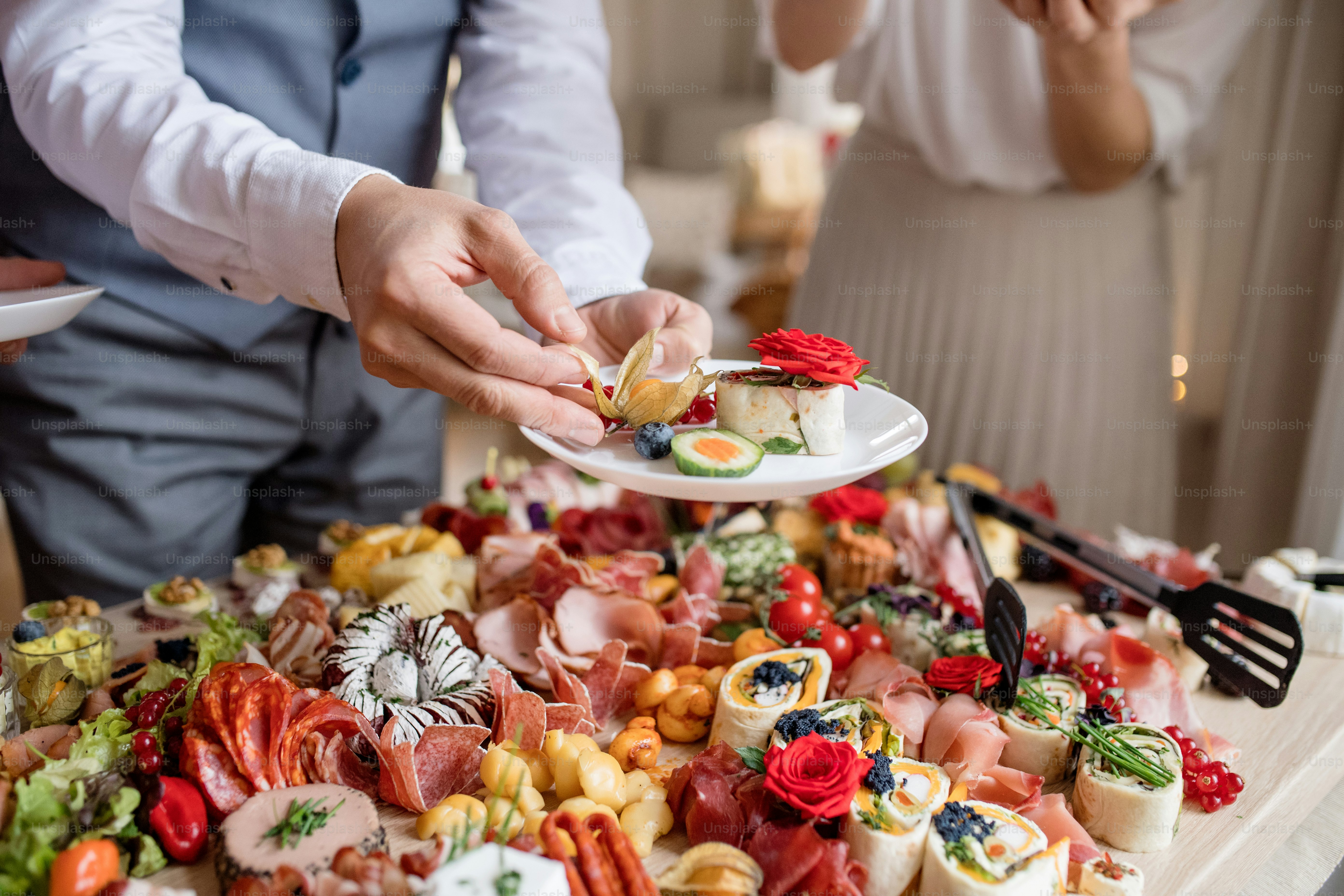 Midsection of a man putting food on a plate on a indoor family birthday party.