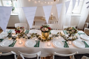 A top view of table set for a meal indoors in a room on a party, a wedding or family celebration.