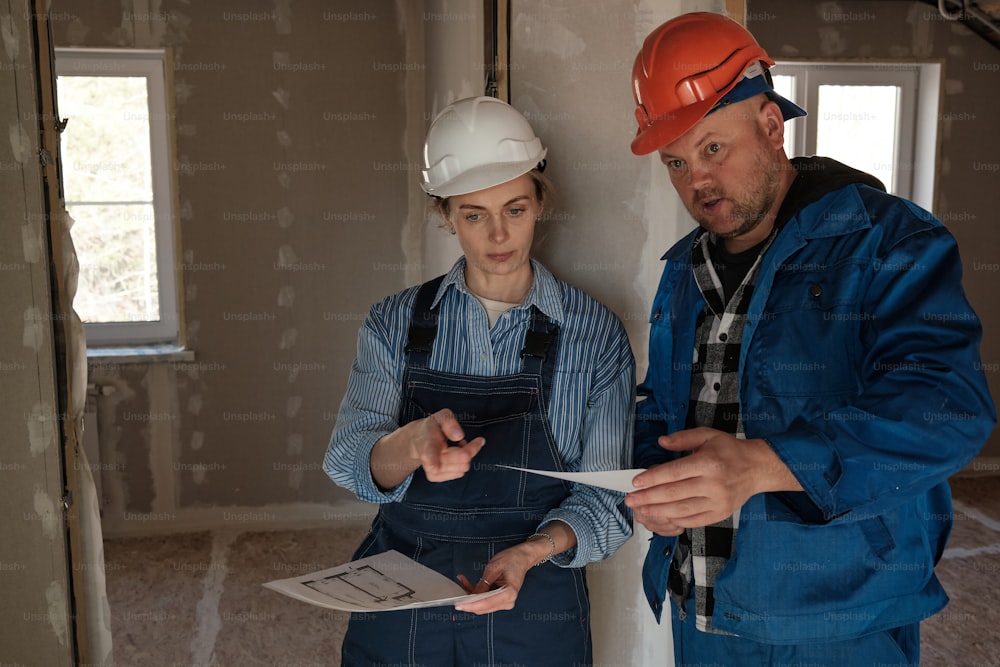 a man and a woman standing in a room under construction