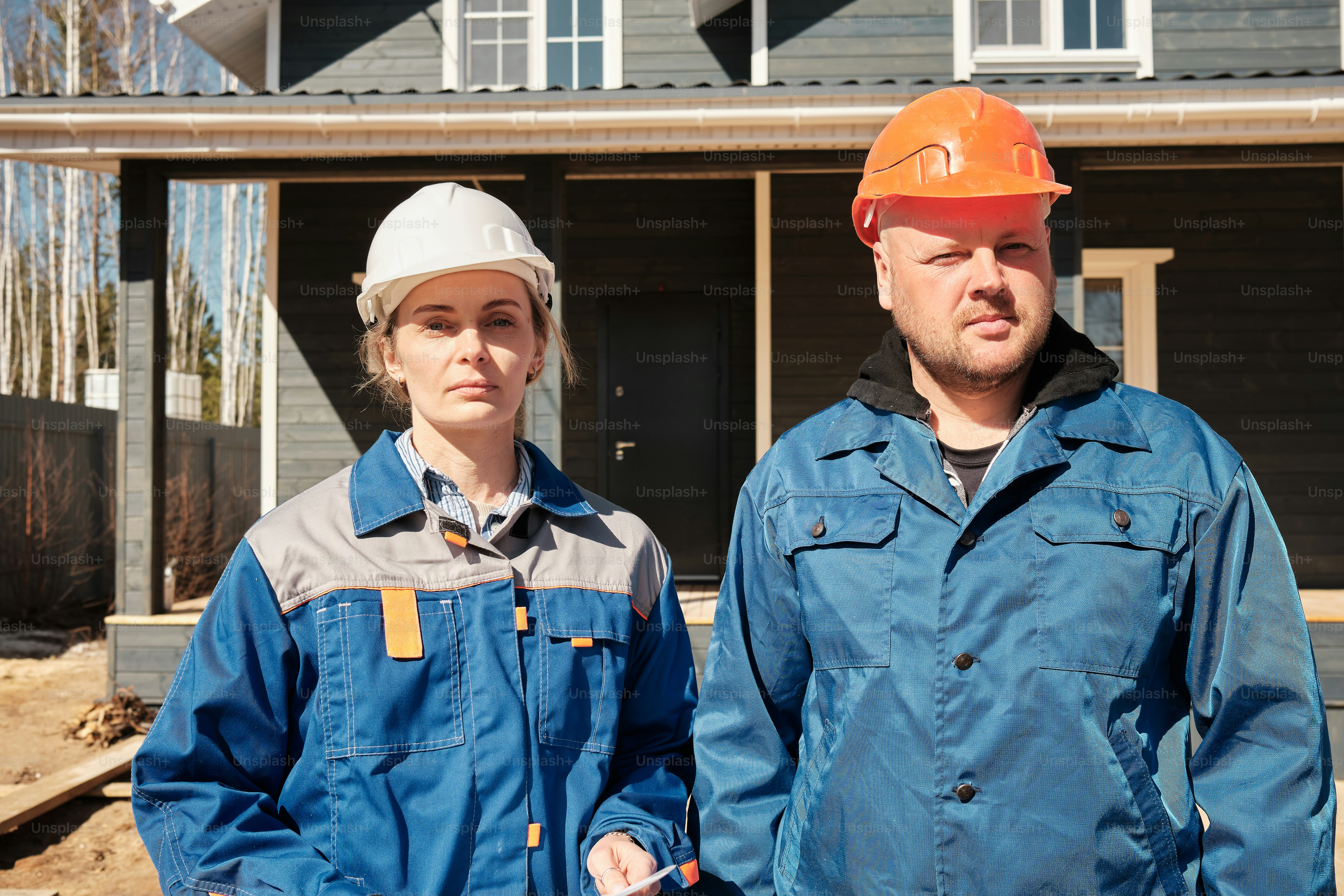 a man and a woman standing in front of a house