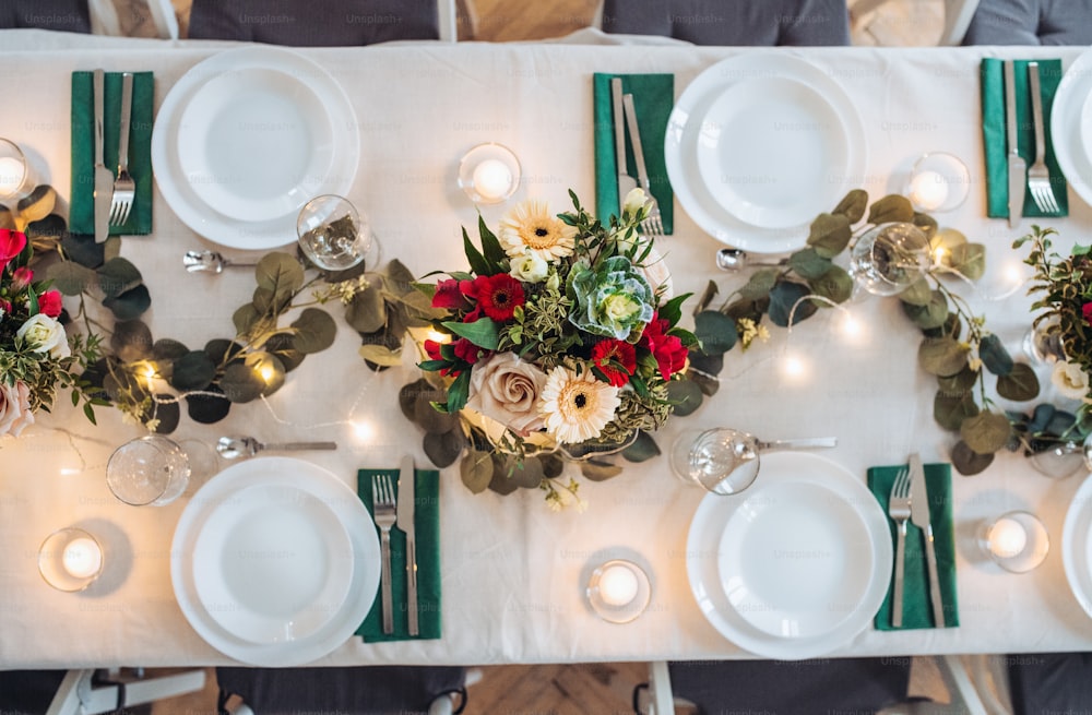 A top view of table set for a meal indoors in a room on a party, a wedding or family celebration.