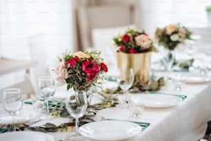 A table set for a meal indoors in a room on a party, a wedding or family celebration.