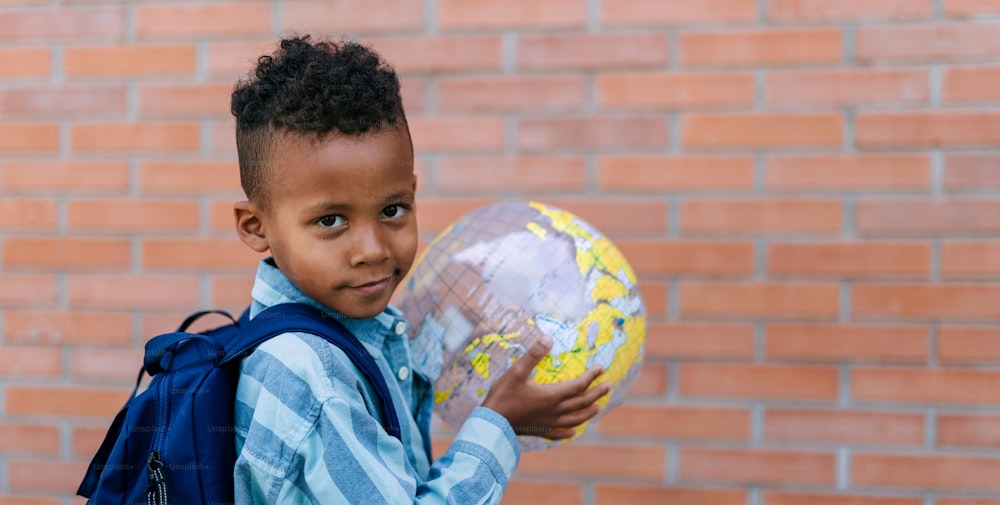 Multiracial boy playing outdoor with a beach ball.