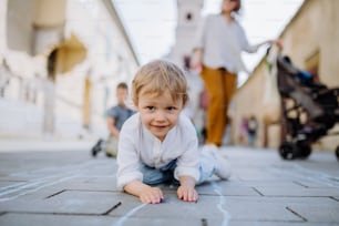 A cute girl lying on asphalt with chalk drawing of games for kids on summer sunny day. Creative development of children.