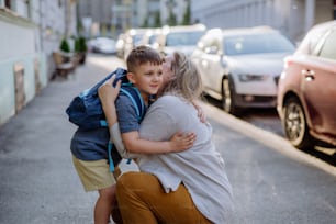 A mother hugs her young son on the way to school, and a mother and boy say goodbye before school.