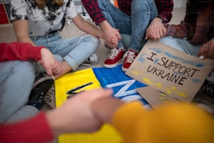 Um close-up de estudantes orando pela Ucrânia na escola.