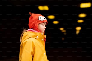 A little girl with Down syndrome outdoors at nigh in winter.