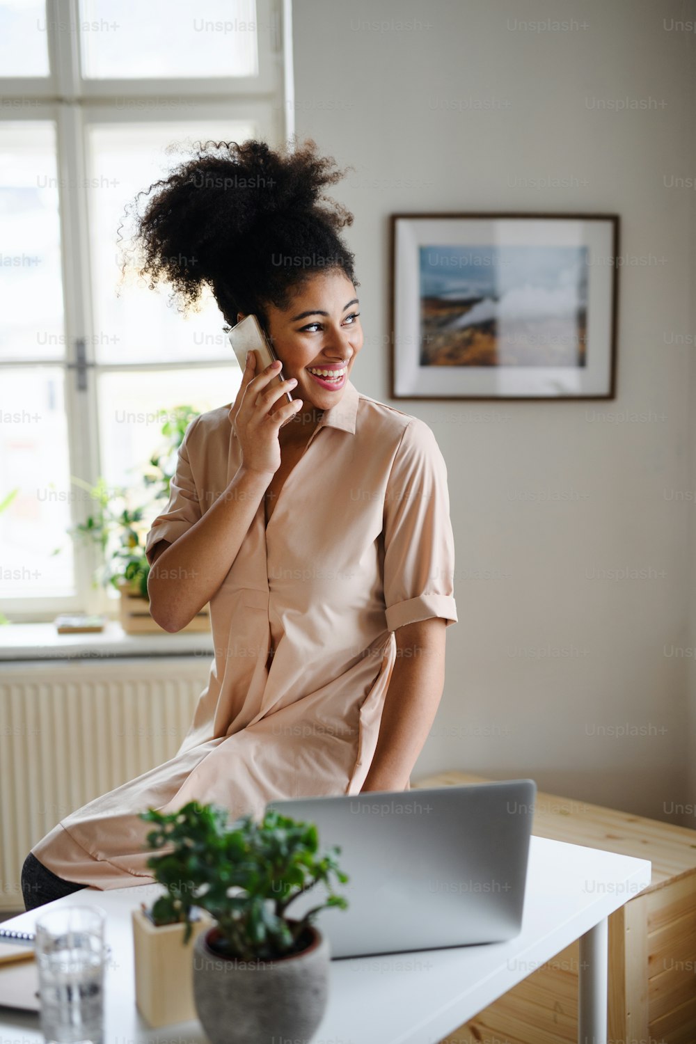 Portrait de jeune femme avec ordinateur portable et smartphone à l’intérieur à la maison, concept de bureau à domicile.