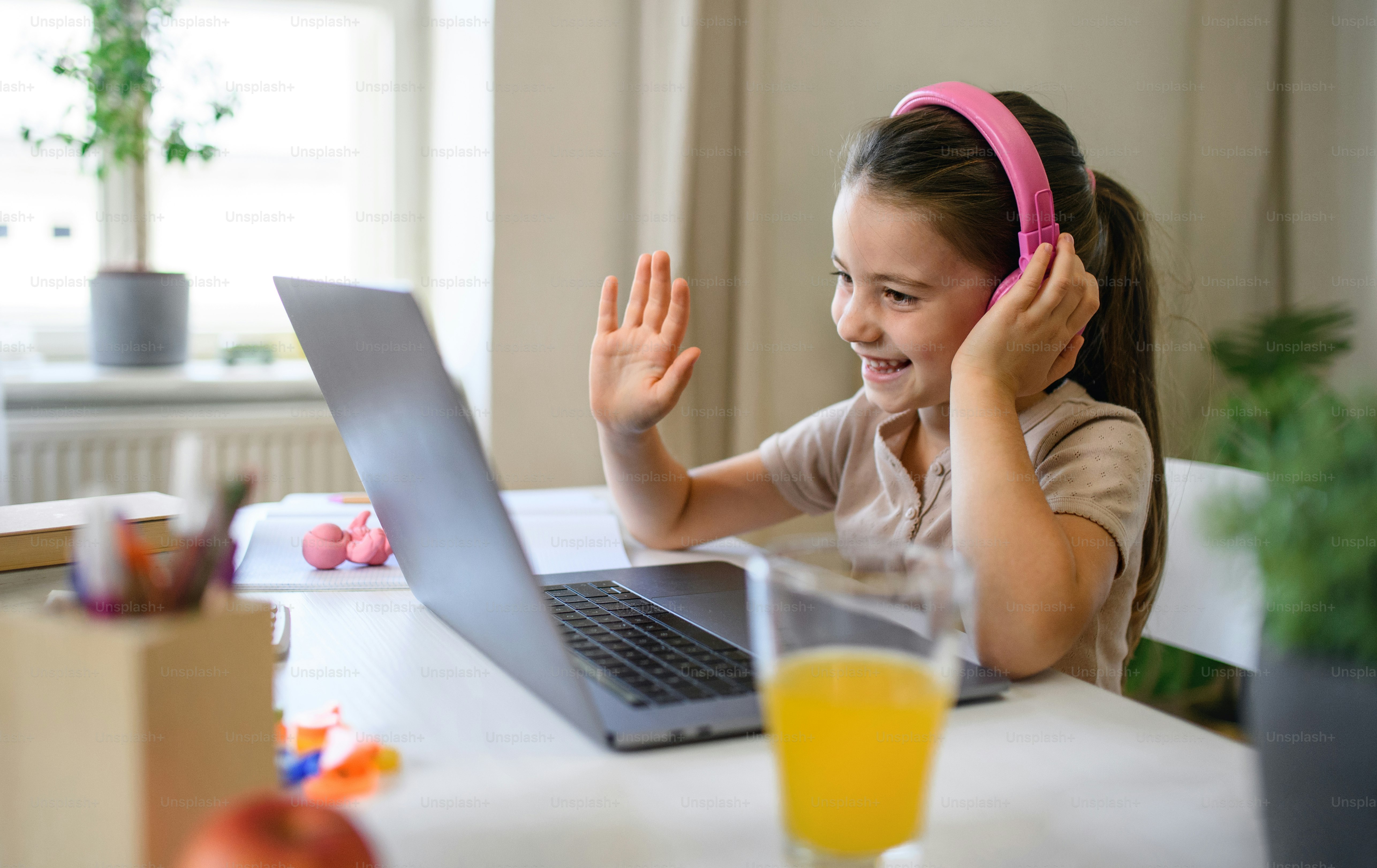 Studentessa che ha lezioni online al chiuso a casa, saluto insegnante e concetto di coronavirus.