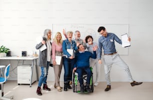 Groupe de personnes âgées joyeuses assistant à un cours d’éducation informatique et technologique.