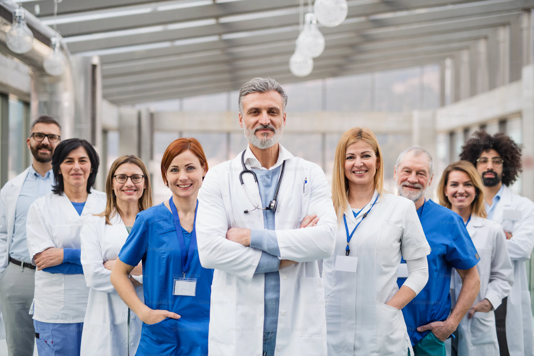 A group of doctors standing in a hospital corridor, looking at camera