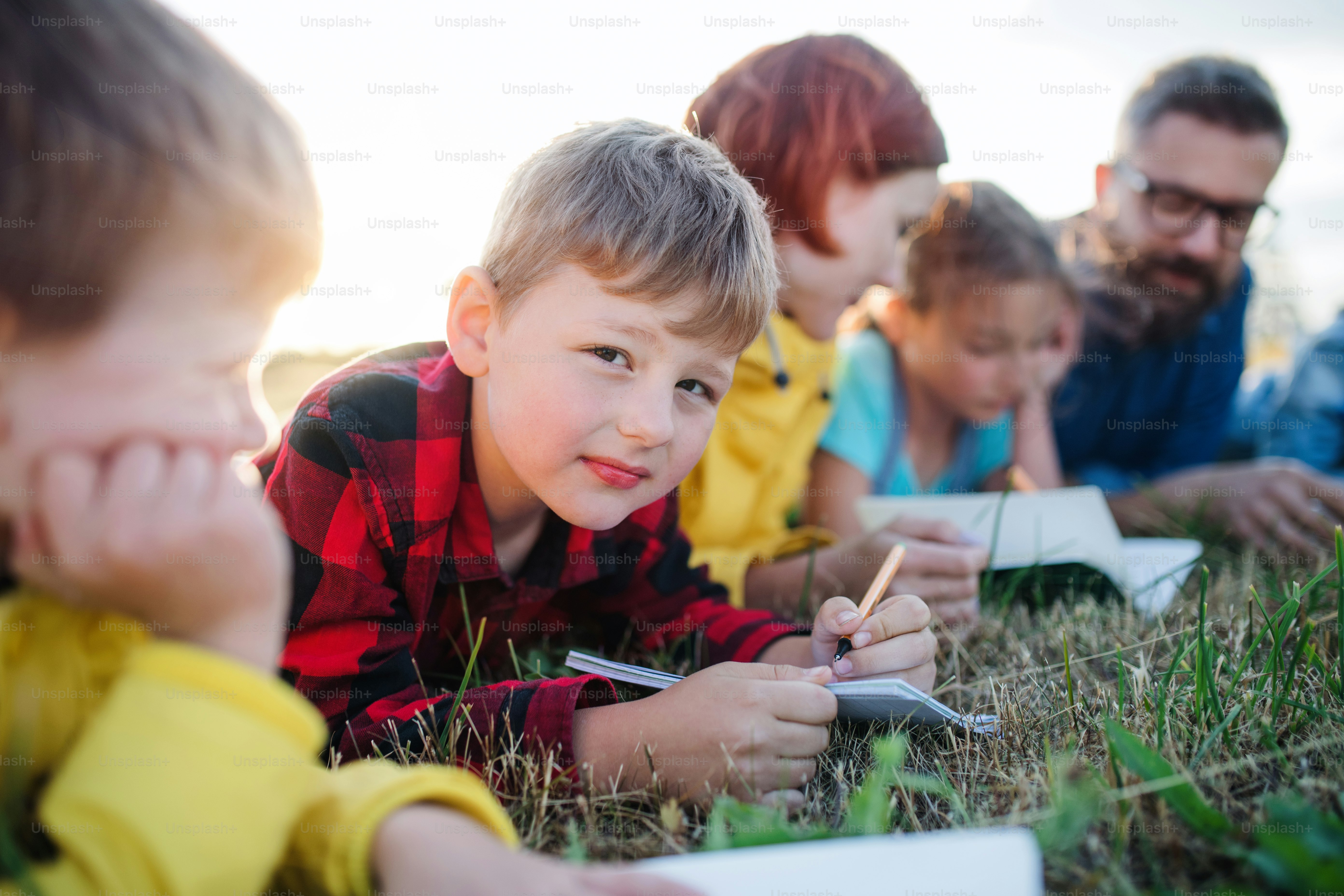 自然の中で遠足をしている先生と小さな学校の子供たちのグループ。