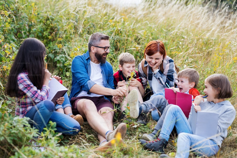 A group of small school children with teacher on field trip in nature.