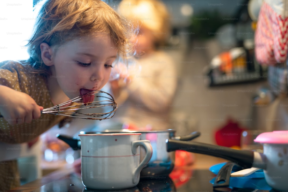 행복한 어�린 소년과 소녀는 집 부엌에서 요리를 돕는다.