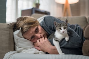 Donna con gatto in casa sul divano a casa sensazione stressata, concetto di salute mentale.
