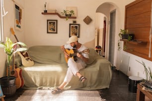 a man sitting on a couch playing a guitar