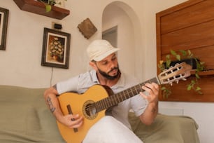 a man sitting on a couch playing a guitar