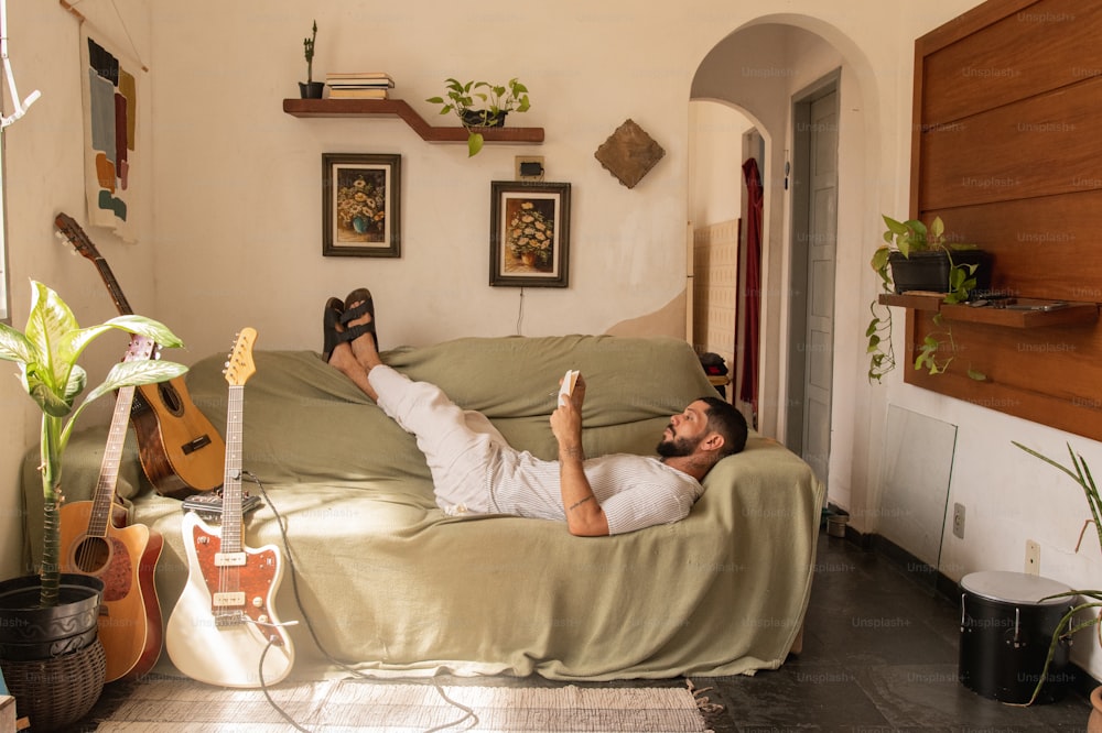 a man laying on a bed with a guitar