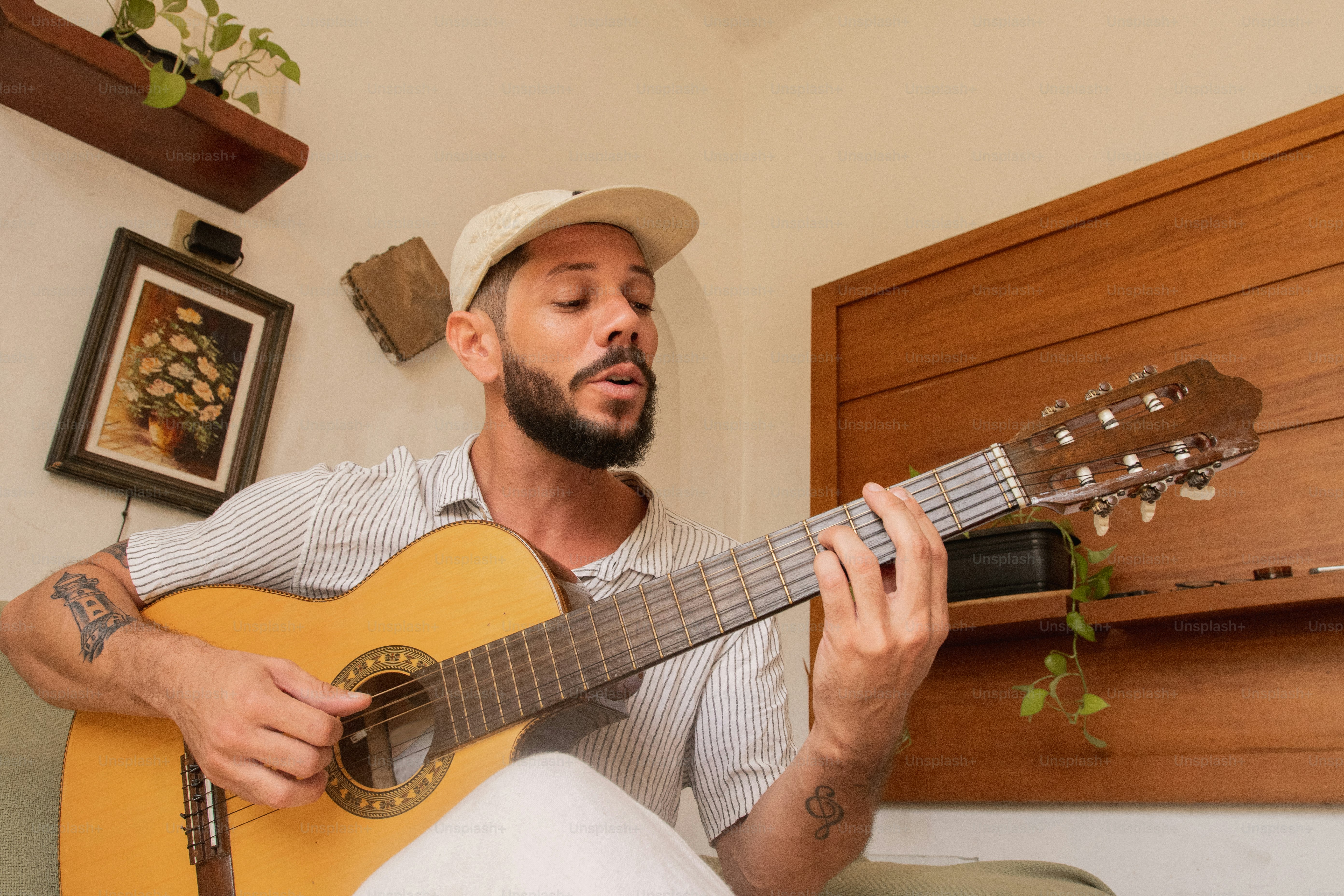 a man sitting on a couch playing a guitar