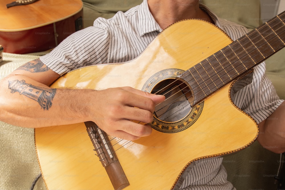 a man holding a guitar in his right hand