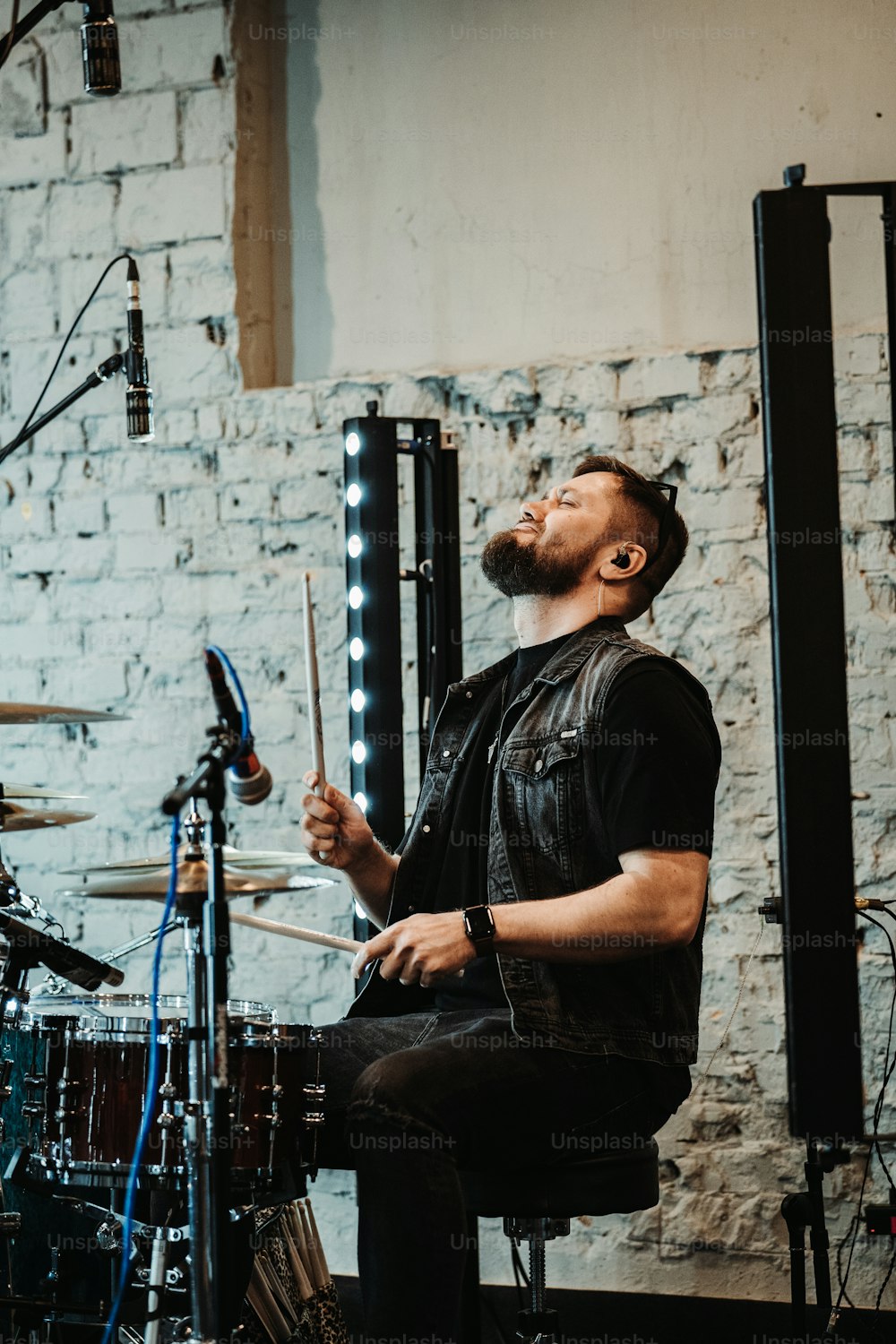 a man sitting on a stool playing drums