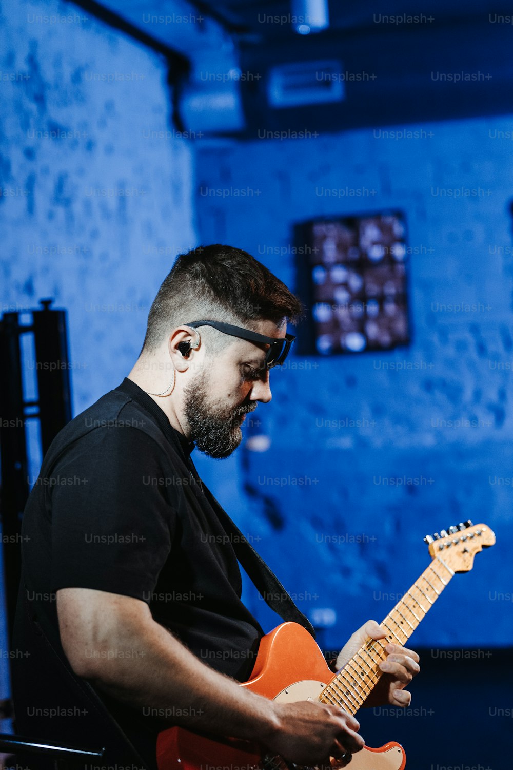 Un hombre con barba tocando una guitarra