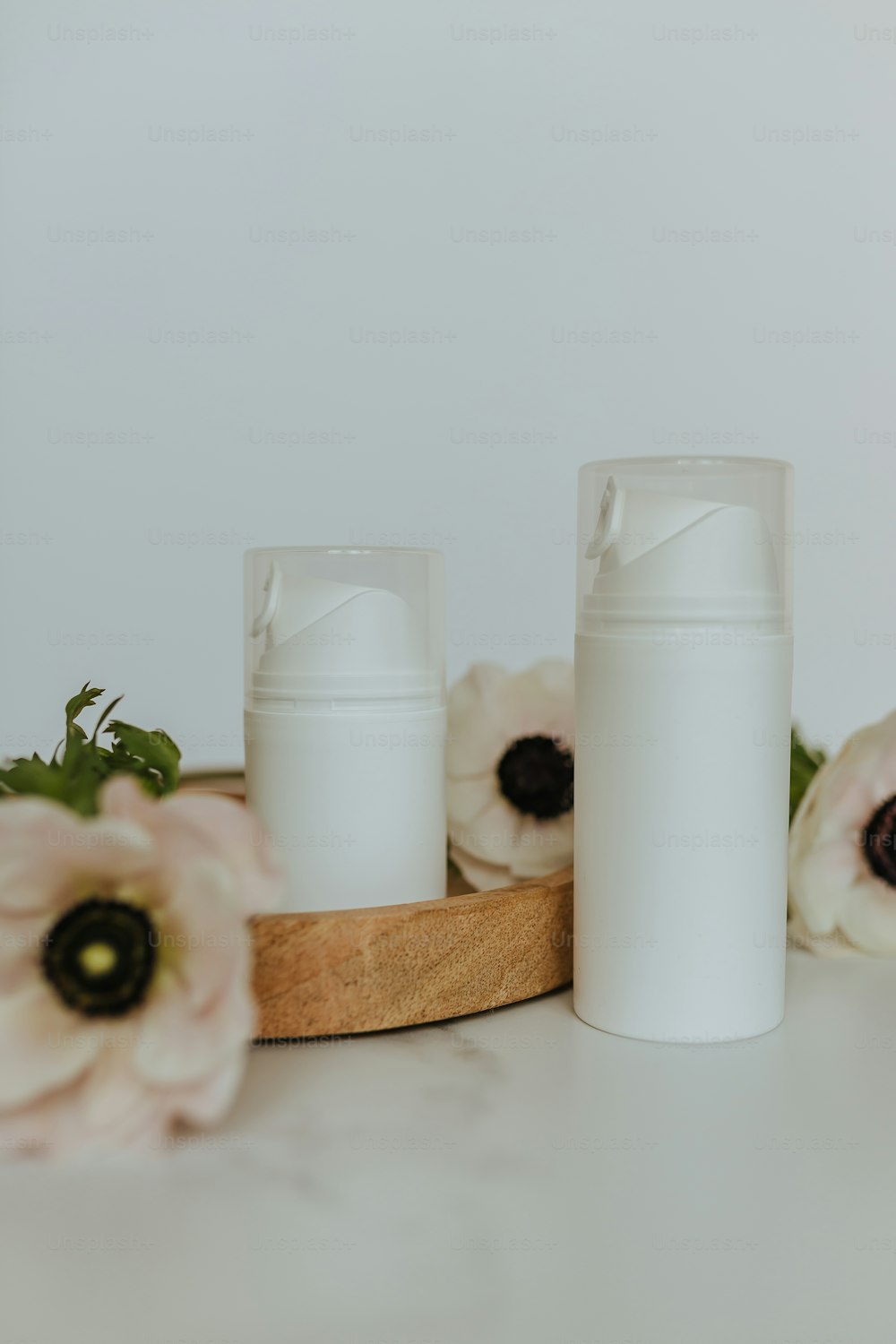 Un par de frascos blancos sentados encima de una mesa