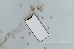 um iphone com uma tela em branco ao lado de um par de clipes