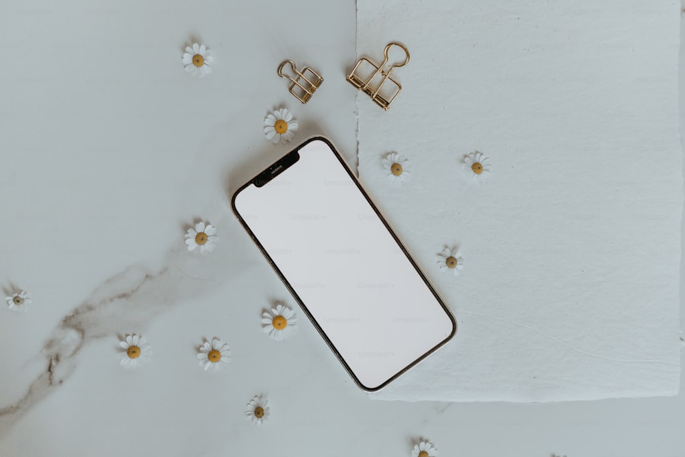 Un iPhone con una pantalla en blanco junto a un par de clips