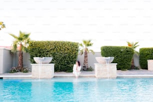 a woman standing in front of a swimming pool