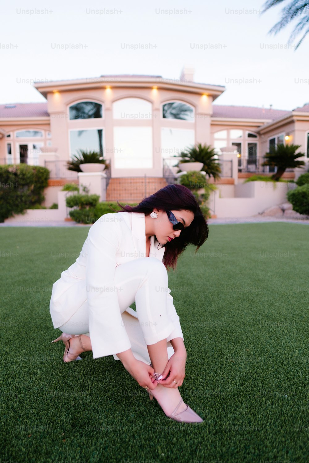 Una donna in un abito bianco inginocchiata sull'erba